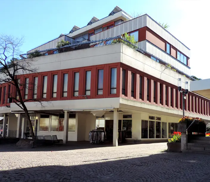 Geschäftsgebäude mit rot-weißer Fassade und überdachtem Eingangsbereich